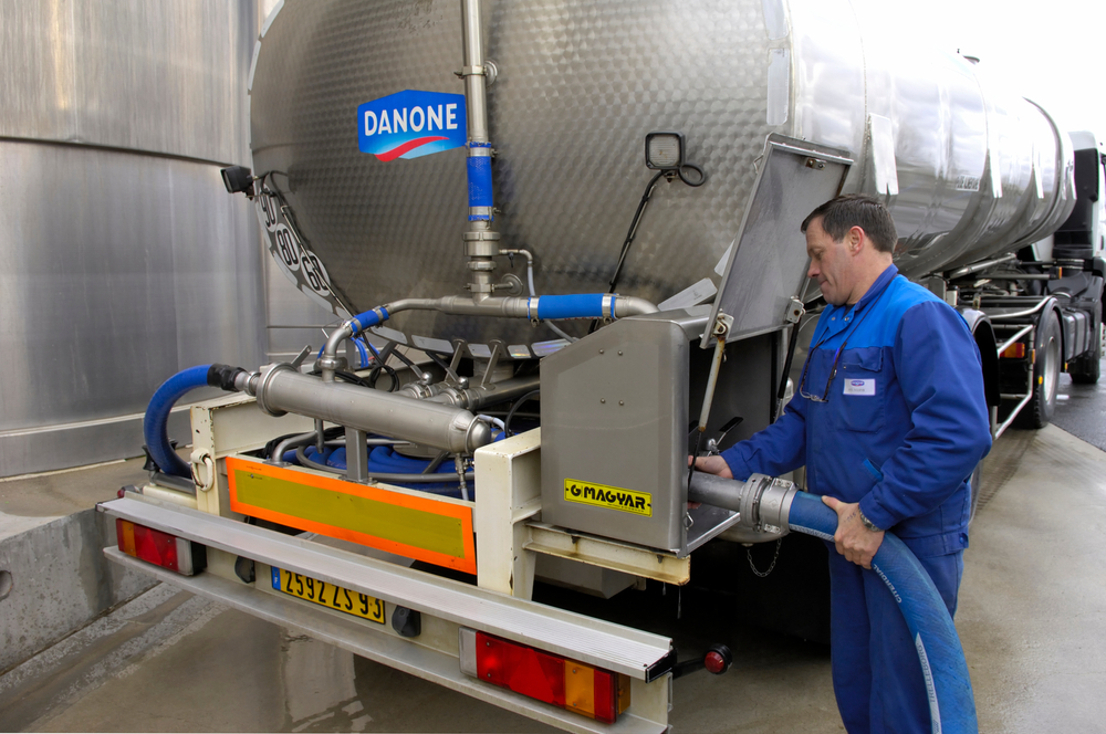 Workers fills up milk storage tank at a Danone dairy plant in Normandy, France, April 2008.