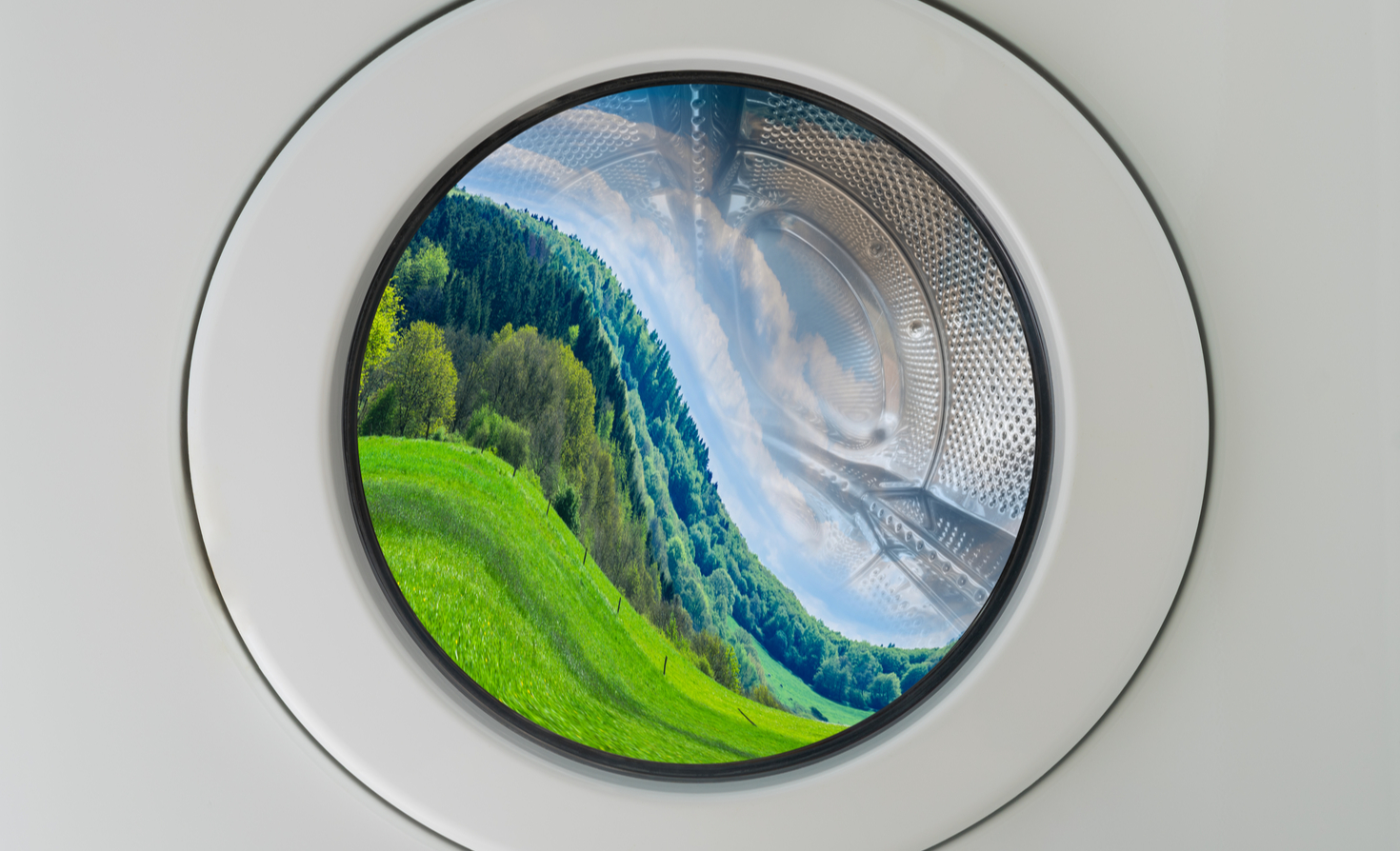 A landscape contorted in the window of a washing machine.