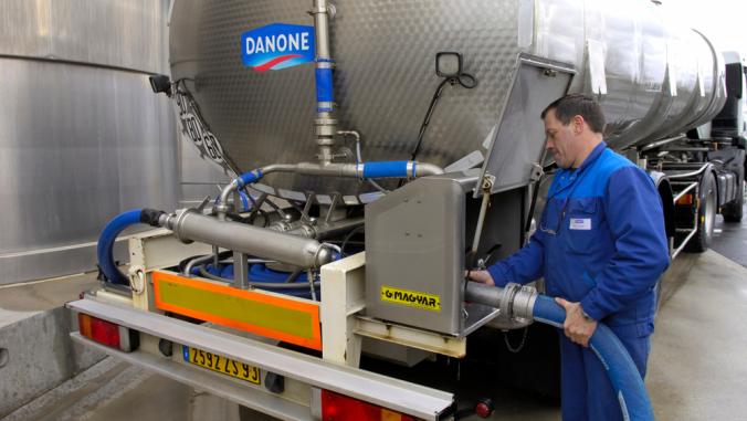 Workers fills up milk storage tank at a Danone dairy plant in Normandy, France, April 2008.