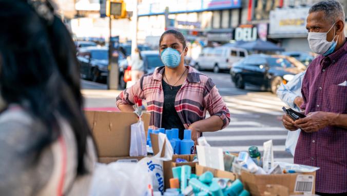 Person wearing a mask sells beauty products at a street stall in Washington Heights, Manhattan in New York City during the COVID-19 pandemic.