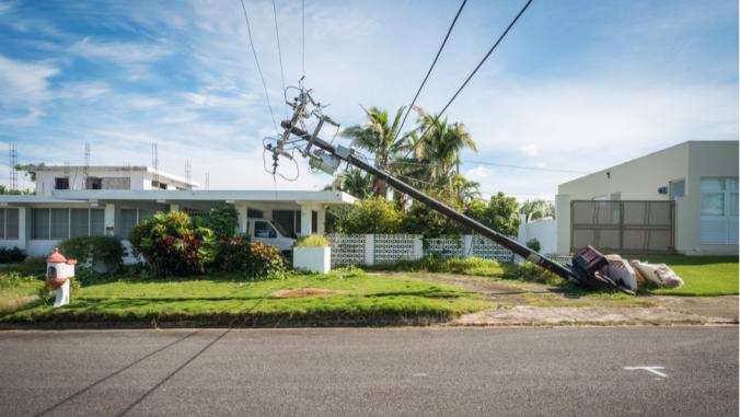 A broken telephone pole leans dangerously close to a house just outside of San Juan in Puerto Rico.