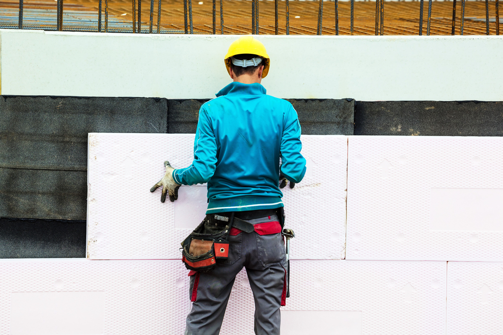 建筑工人在建筑工地安装建筑物保温