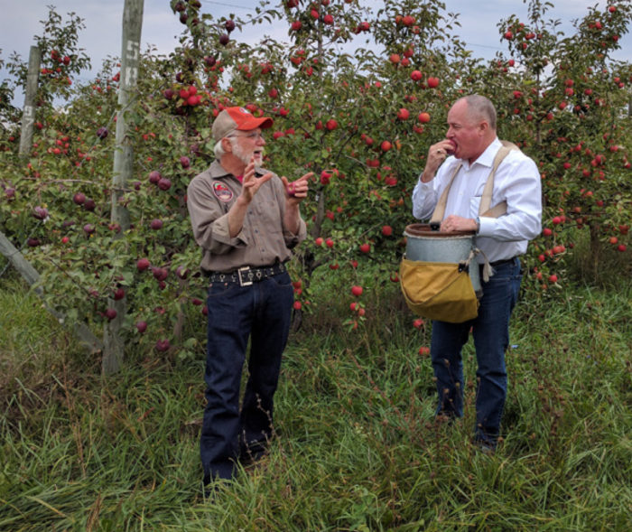 密歇根州的苹果种植者吉姆公案（左）解释他的经营策略，以原美国农业部农场服务局管理瓦尔Dolcini（右）。Koan的苹果酒业务在天气影响苹果生产的年份提供了稳定的现金流。（由萨凡纳Halleaux，USDA照片）