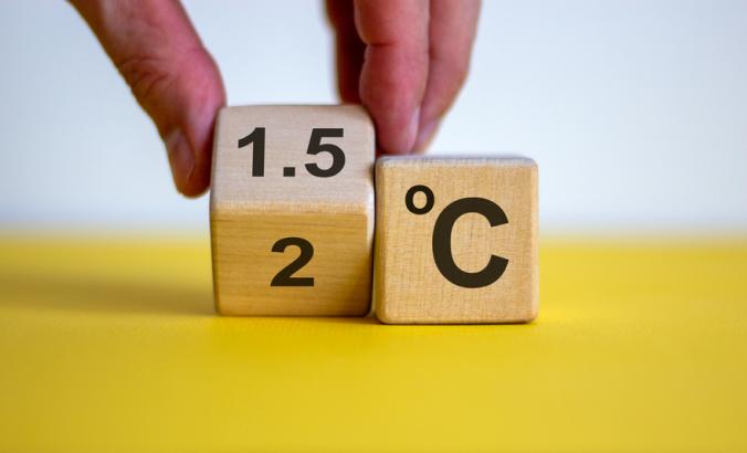 A person's hand turning a cube and changes the expression '2 C' to '1.5 C', or vice versa.