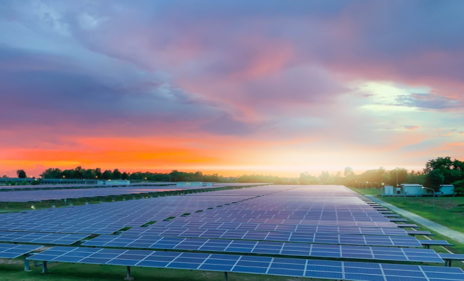 Rows of PV modules. Sunset can be seen in the background.