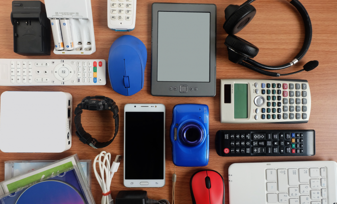 Used modern electronic gadgets — including a calculator, headphones, remote and cell phone — for daily use on wooden floor,