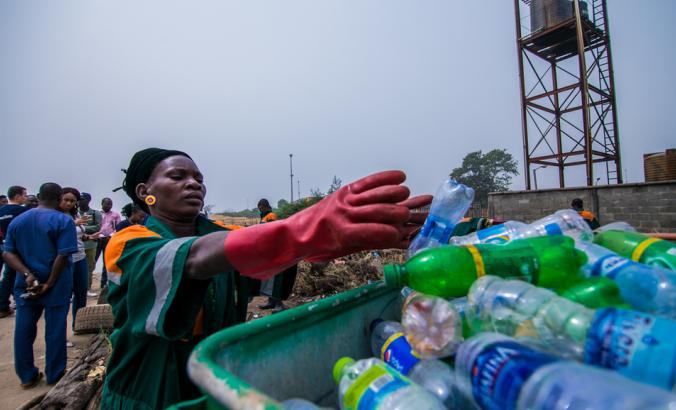 在尼日利亚的拉各斯，一名拾取塑料垃圾的人进入了垃圾桶